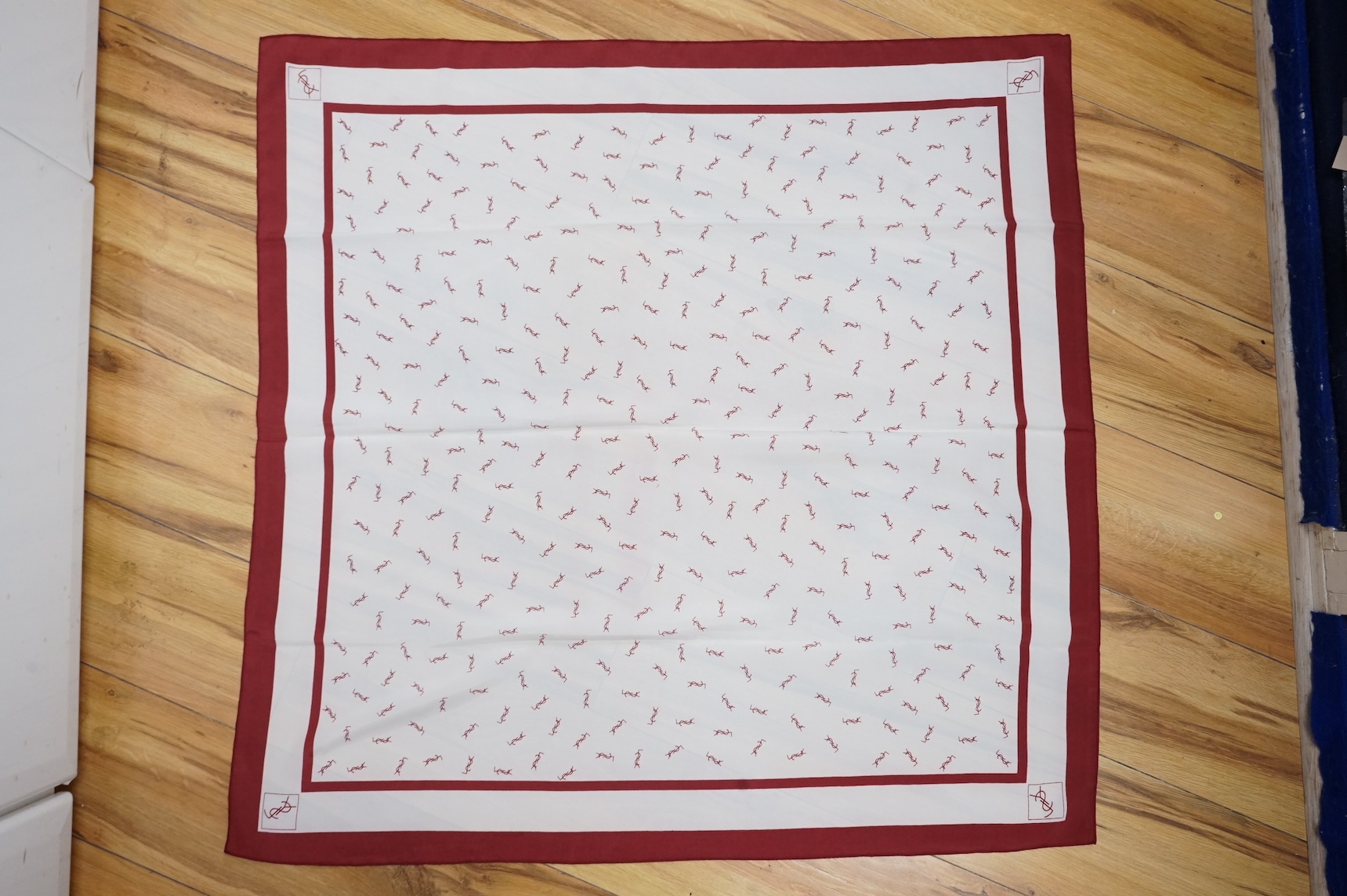 Two Yves Saint Laurent silk scarves comprising a monogrammed example and a patterned brown example with Foulards folding case